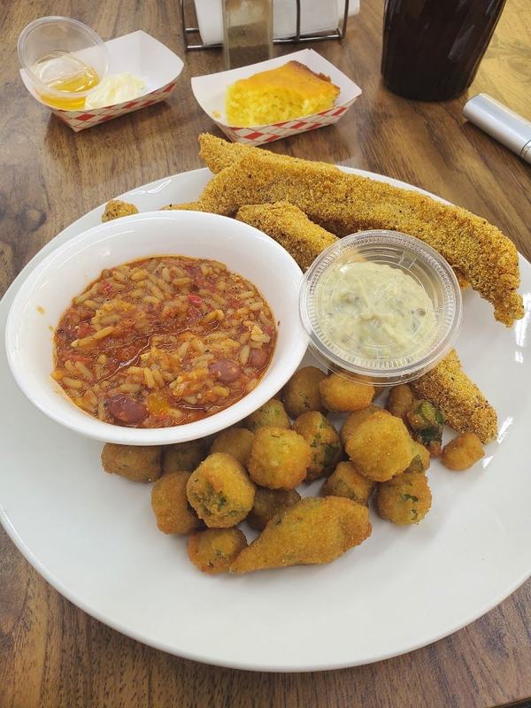 Plate of fried catfish with fried sides and a bowl of red beans and rice