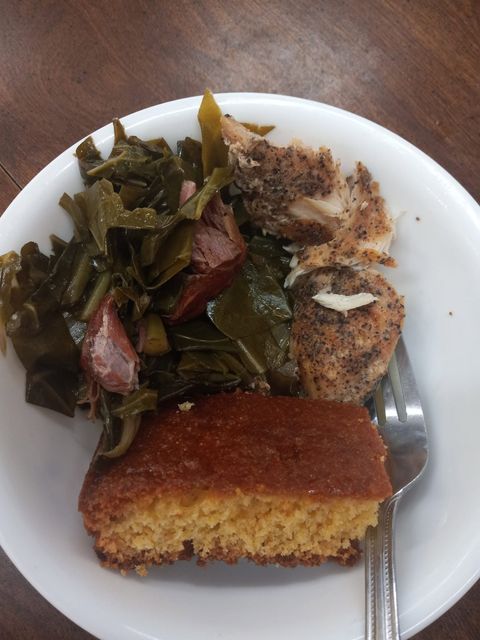 Plate with collard greens, a slice of cornbread and baked chicken